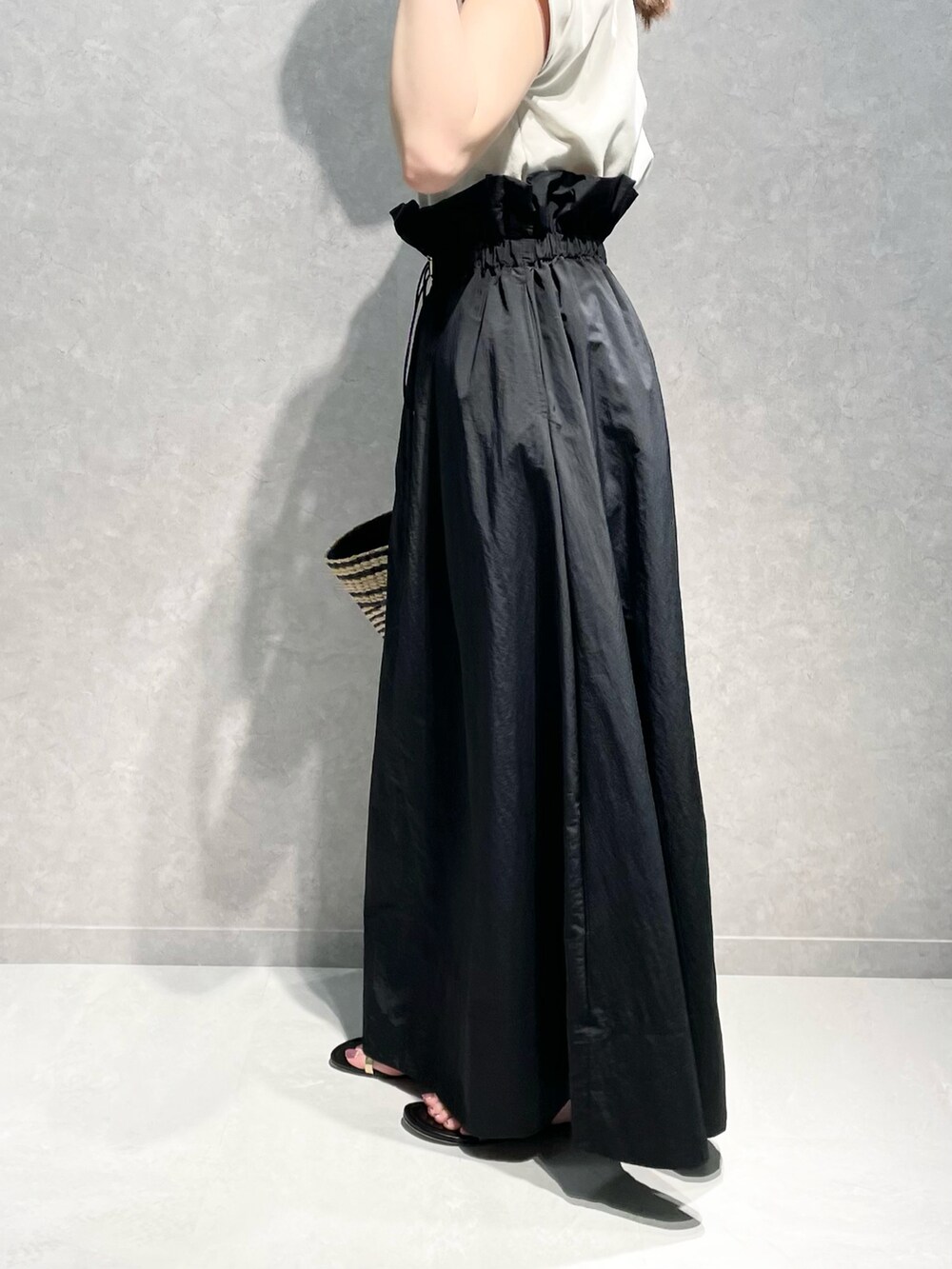 ベージュ系のTシャツ/カットソー、ブラック系のスカート、ブラック系のショルダーバッグを着用したレディースの春コーディネートの3枚目の写真