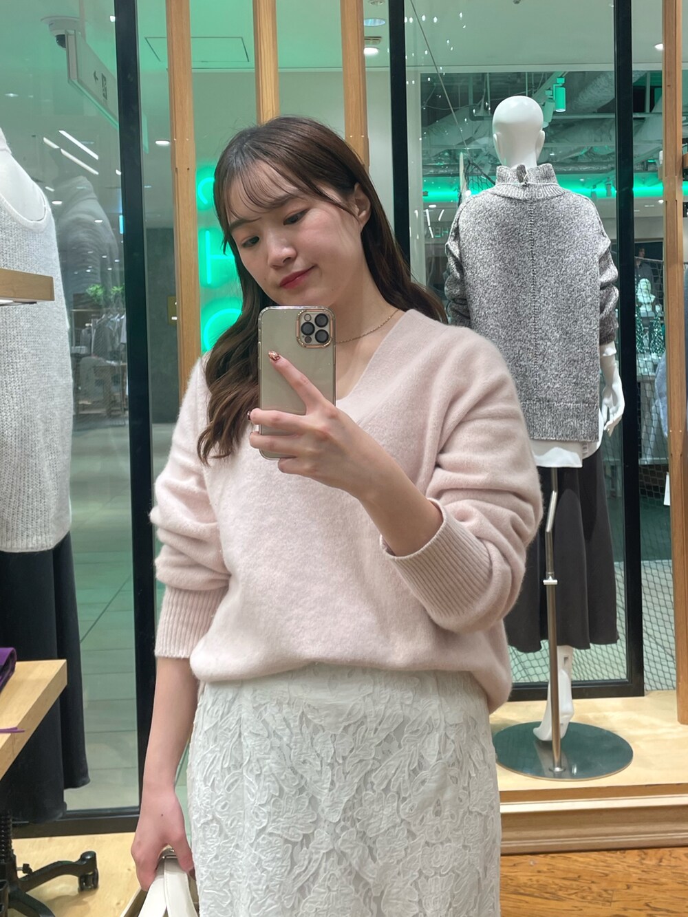 ピンク系のニット/セーター、ホワイト系のスカート、ホワイト系のハンドバッグを着用したレディースの秋コーディネートの2枚目の写真