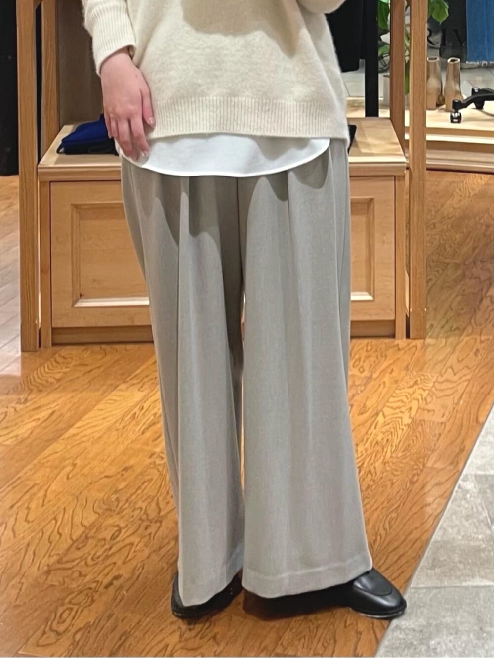 ベージュ系のニット/セーター、ベージュ系のスラックス、ホワイト系のシャツ/ブラウスを着用したレディースの冬コーディネートの3枚目の写真