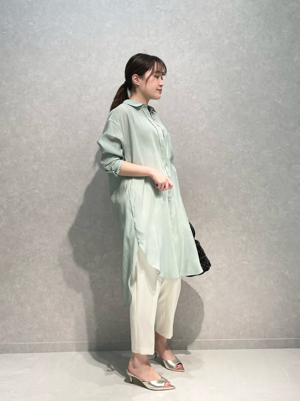 ゴールド系のサンダル、グリーン系のトップス、ホワイト系のその他パンツを着用したレディースの春コーディネートの2枚目の写真