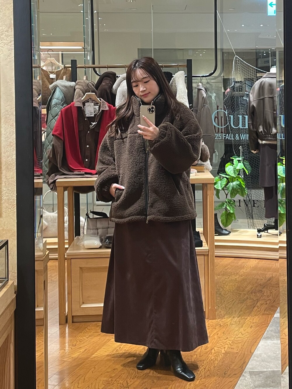 ブラウン系のその他アウター、ブラウン系のスカート、ブラック系のブーツを着用したレディースの秋コーディネートの3枚目の写真