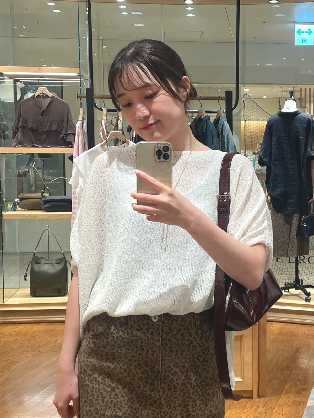 ホワイト系のニット/セーター、ブラウン系のスカート、ブラック系のパンプスを着用したレディースの夏コーディネートの2枚目の写真