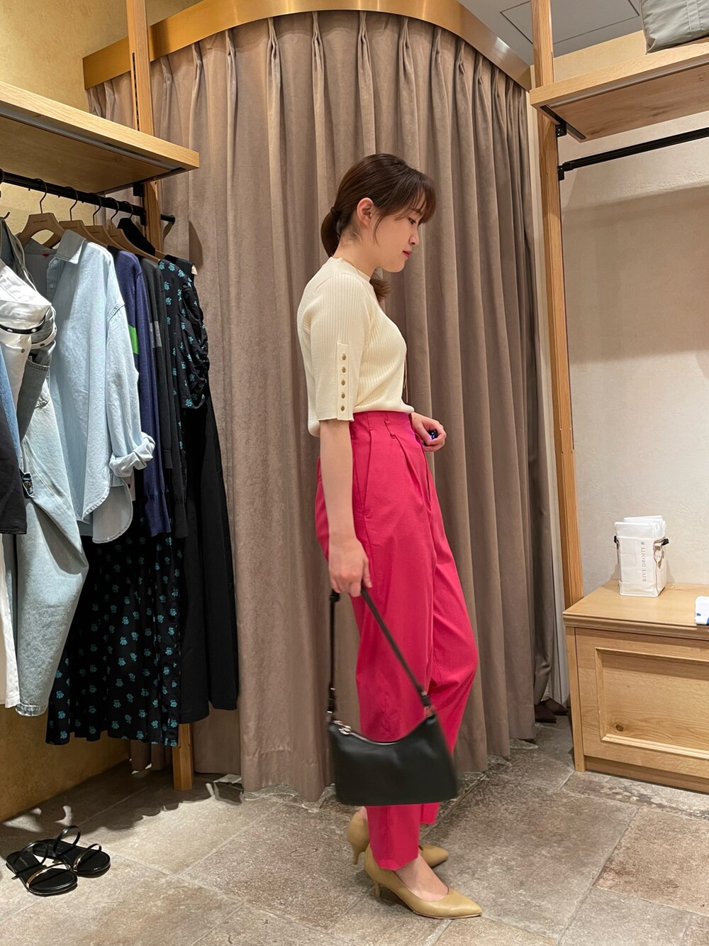 ホワイト系のニット/セーター、ピンク系のパンツ、ブラック系のハンドバッグを着用したレディースの夏コーディネートの2枚目の写真