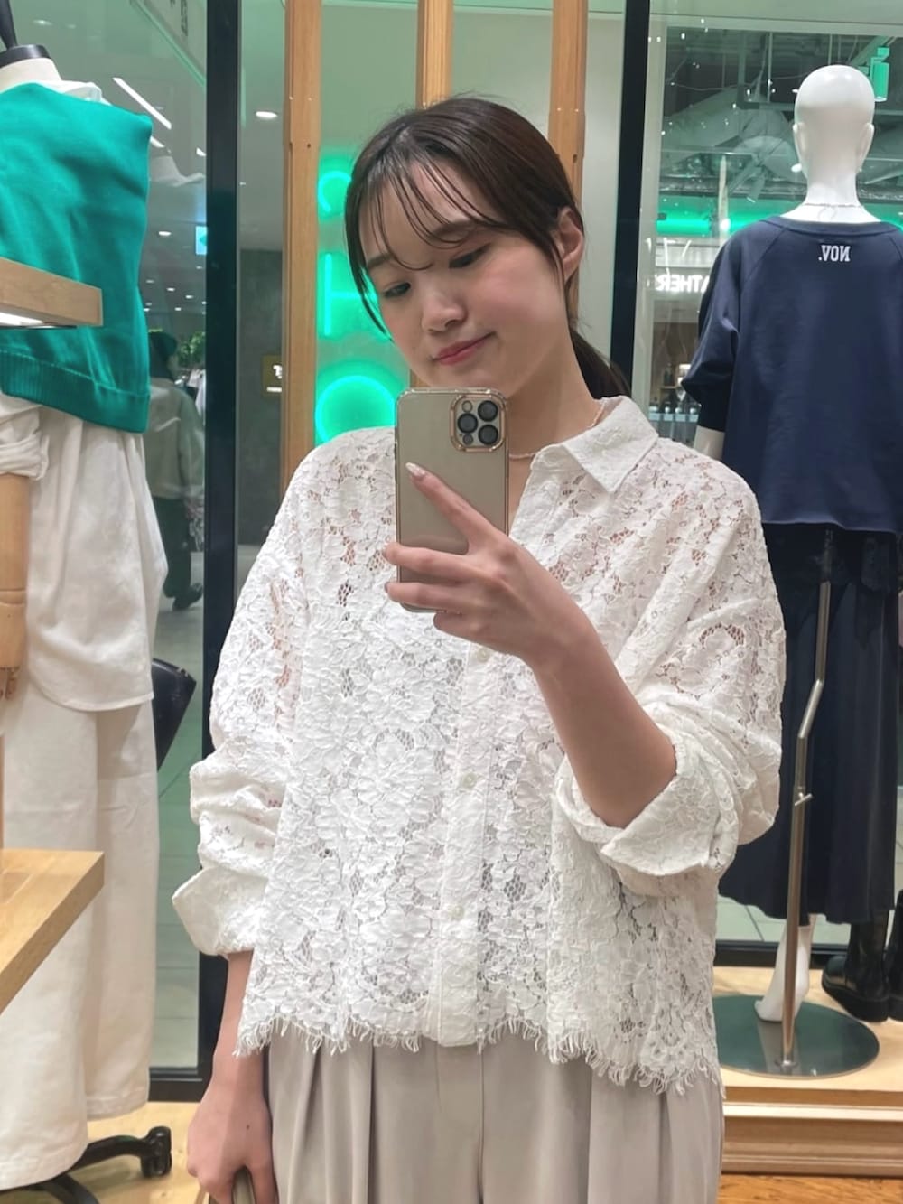 ホワイト系のシャツ/ブラウス、グレー系のスラックス、ベージュ系のハンドバッグを着用したレディースの冬コーディネートの2枚目の写真