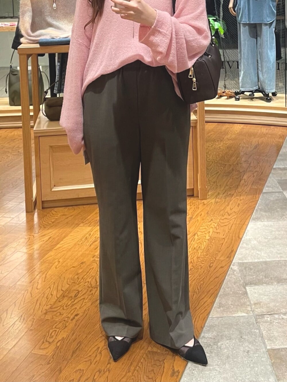 ピンク系のニット/セーター、ブラック系のショルダーバッグ、ブラウン系のその他パンツを着用したレディースの秋コーディネートの3枚目の写真