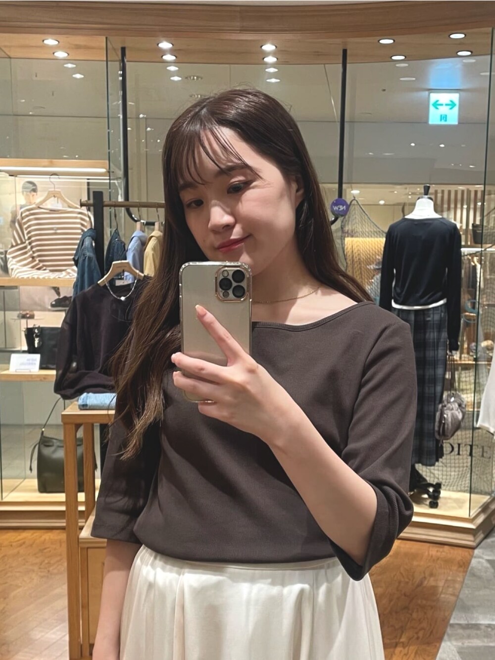 ホワイト系のスカート、ベージュ系のその他シューズ、ブラウン系のボストンバッグを着用したレディースの夏コーディネートの2枚目の写真