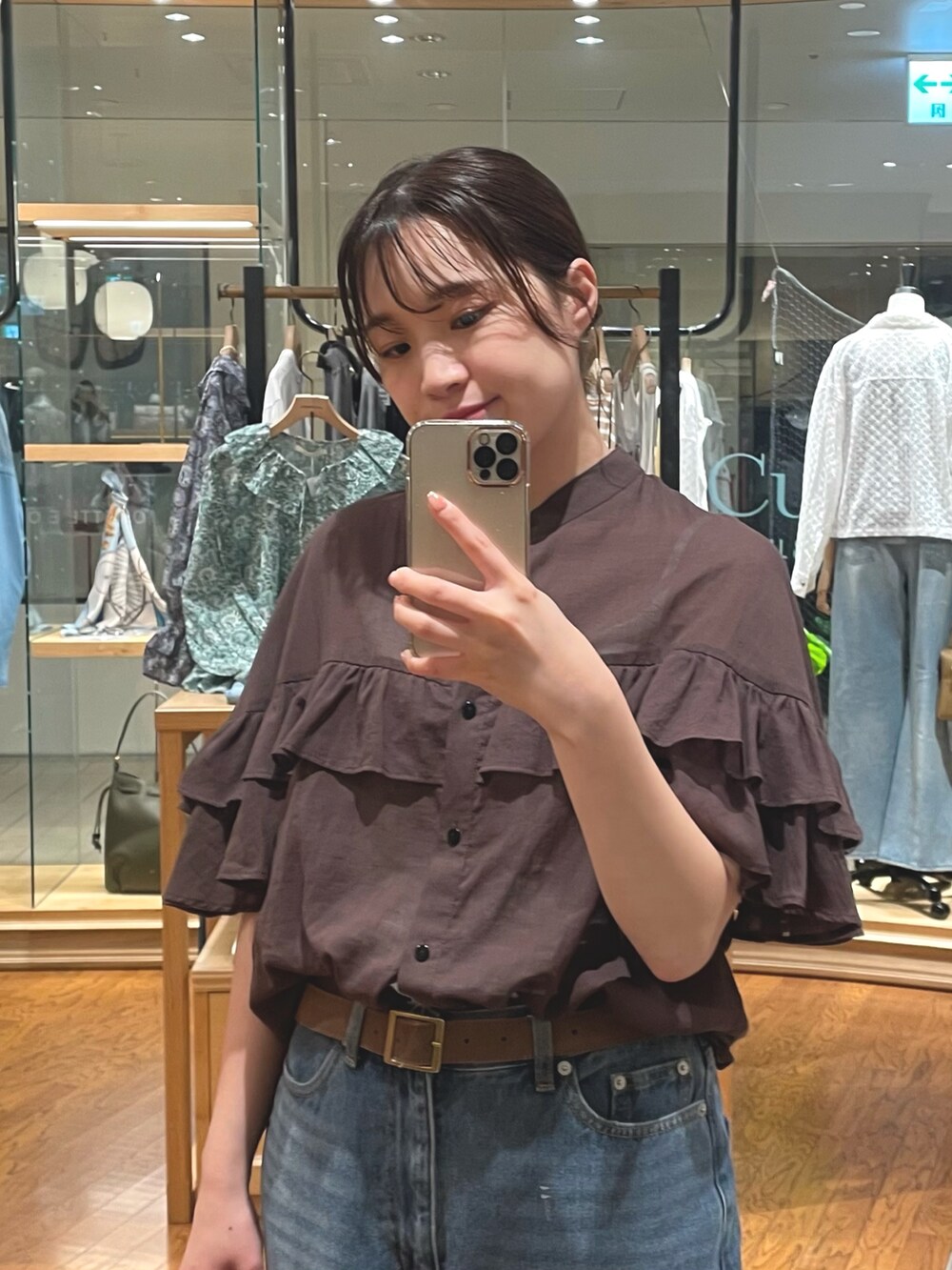 ブラウン系のシャツ/ブラウス、ブルー系のデニムパンツ、ブラウン系のショルダーバッグを着用したレディースの夏コーディネートの2枚目の写真