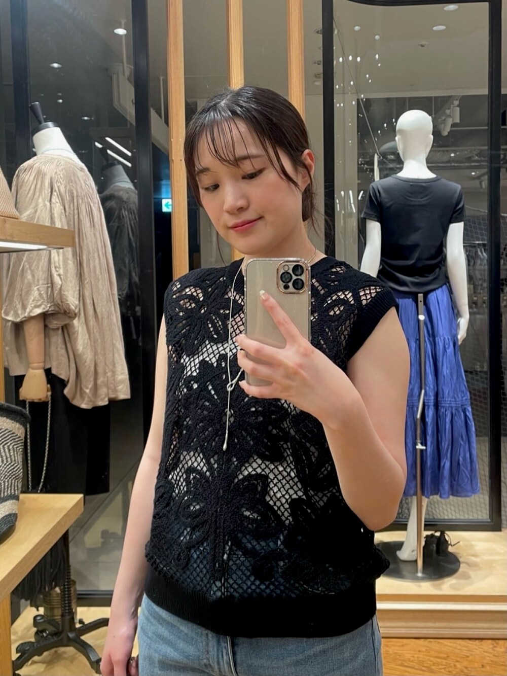 ブラック系のニット/セーター、ブルー系のデニムパンツ、ブラック系のサンダルを着用したレディースの夏コーディネートの2枚目の写真