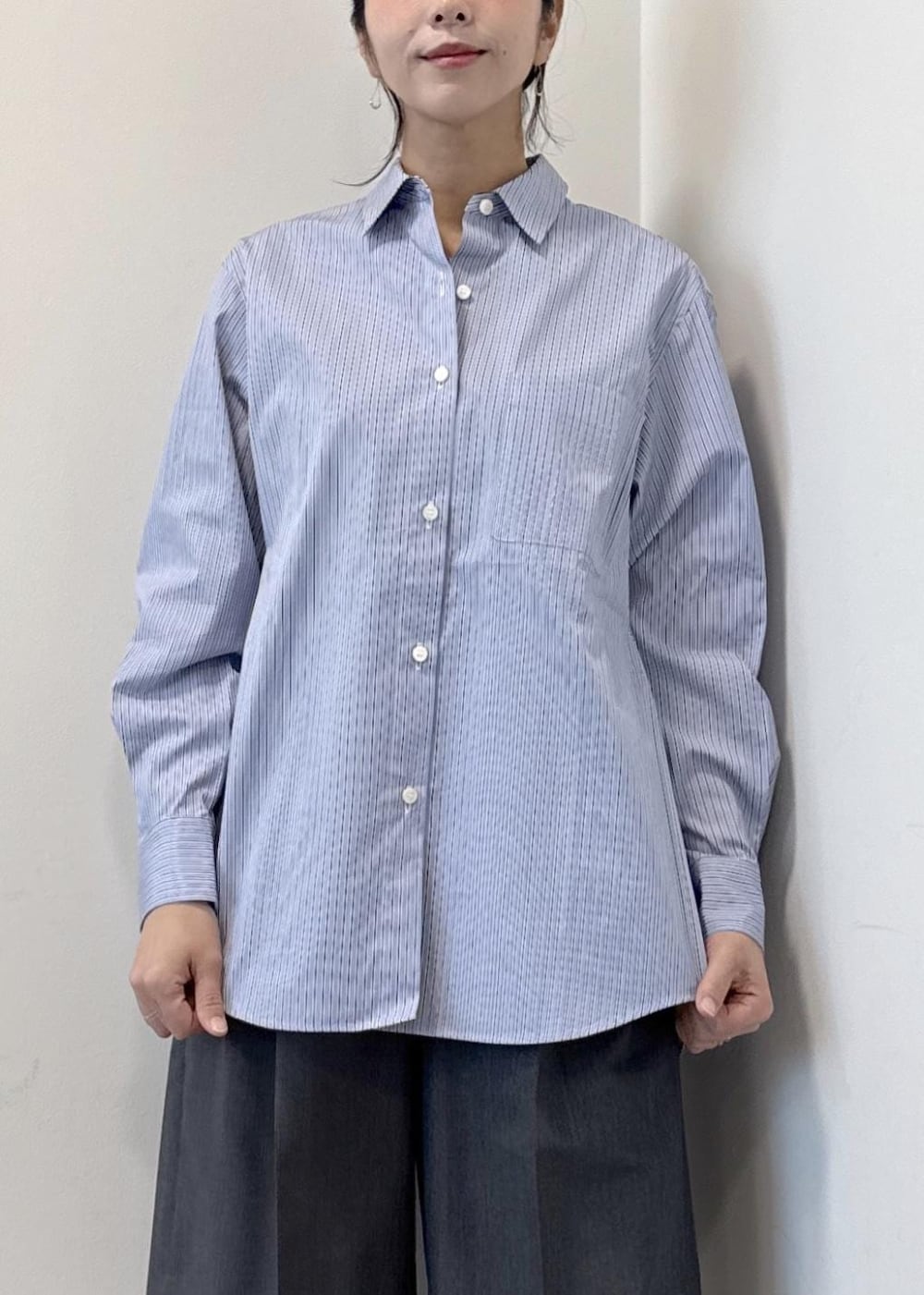 ブルー系のシャツ/ブラウス、グレー系のその他パンツ、ブラック系のブーツを着用したレディースの秋コーディネートの8枚目の写真