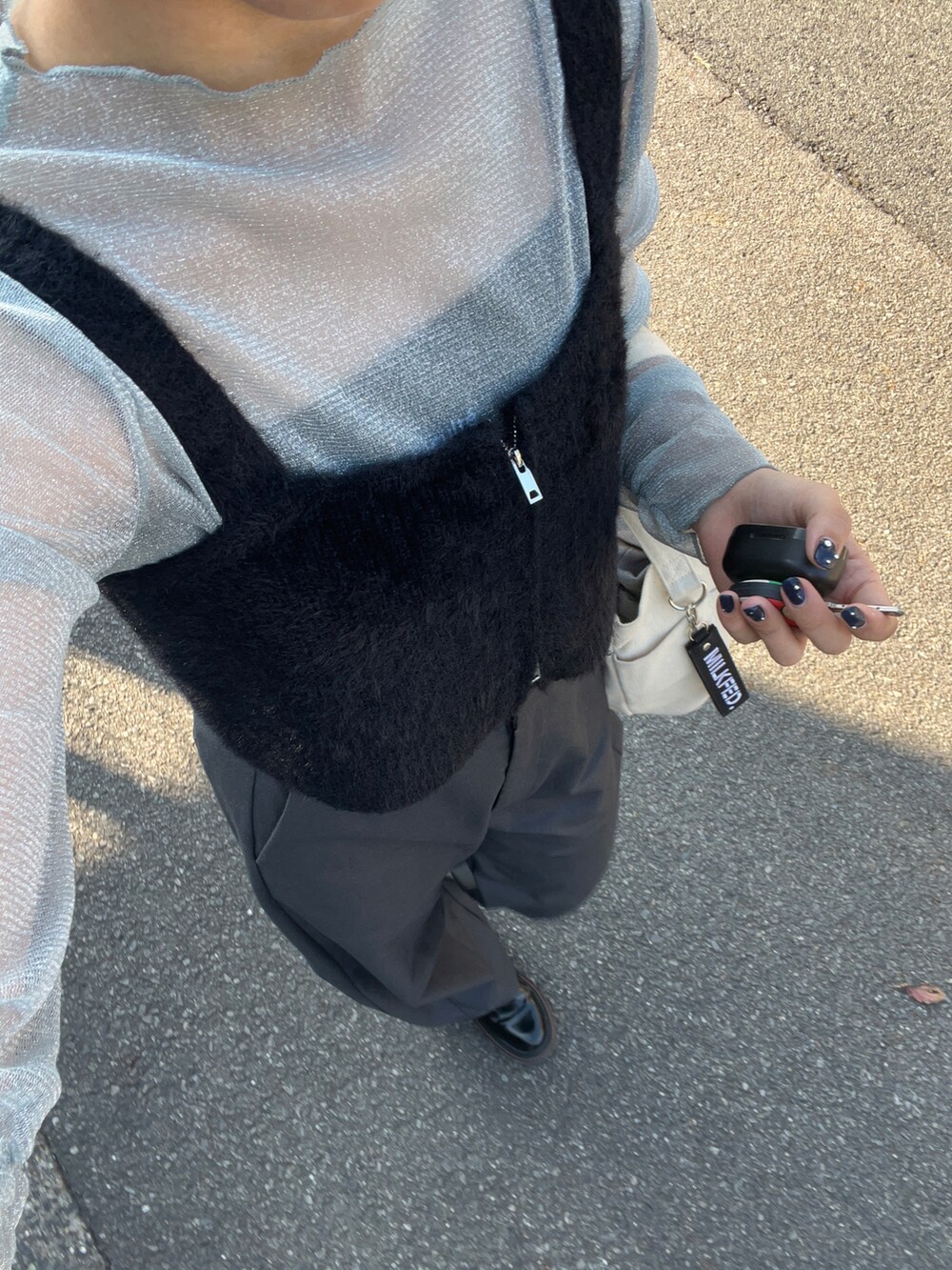 ブルー系のTシャツ/カットソー、ブラック系のベスト、グレー系のスラックスを着用したレディースの秋コーディネートの2枚目の写真