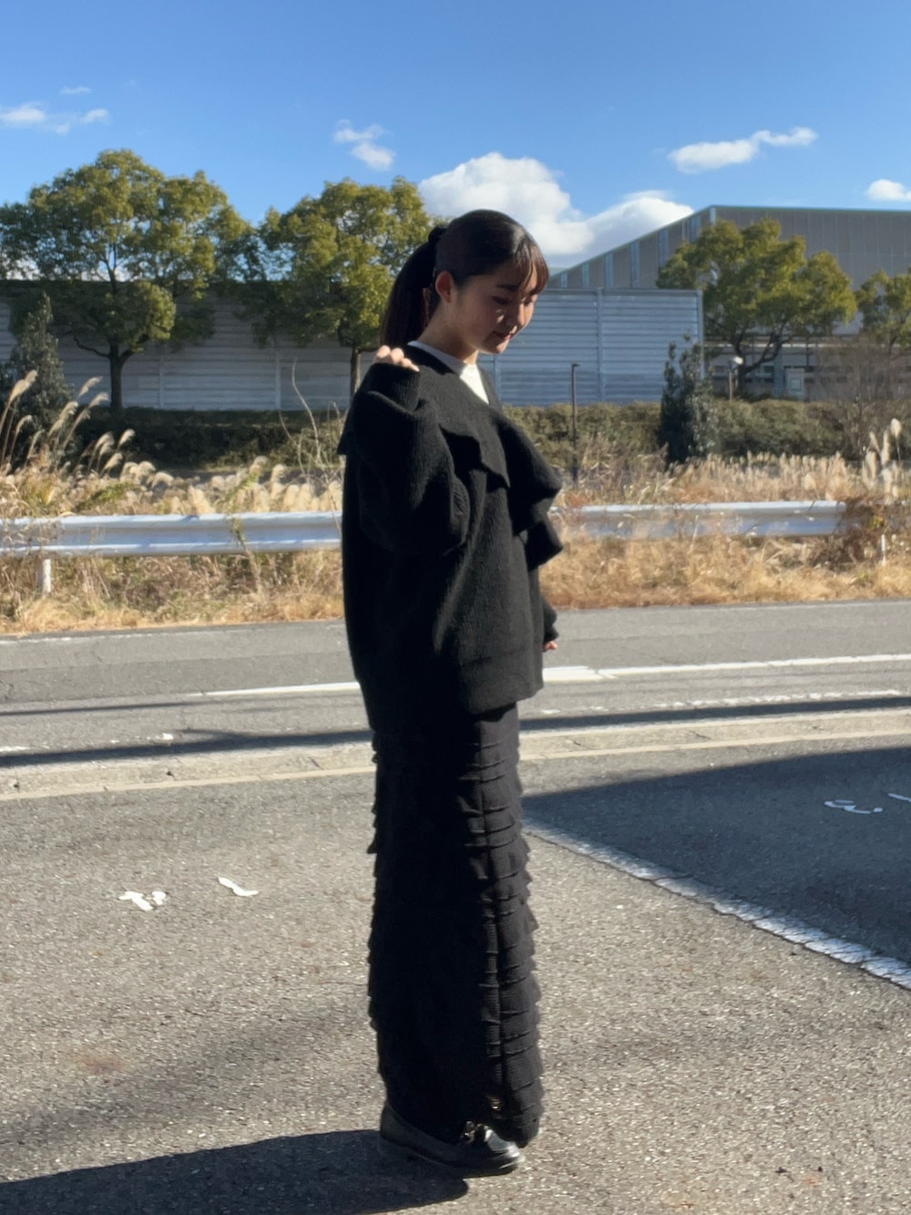 ブラック系のニット/セーター、ブラック系のスカート、ブラック系のローファーを着用したレディースの冬コーディネートの2枚目の写真