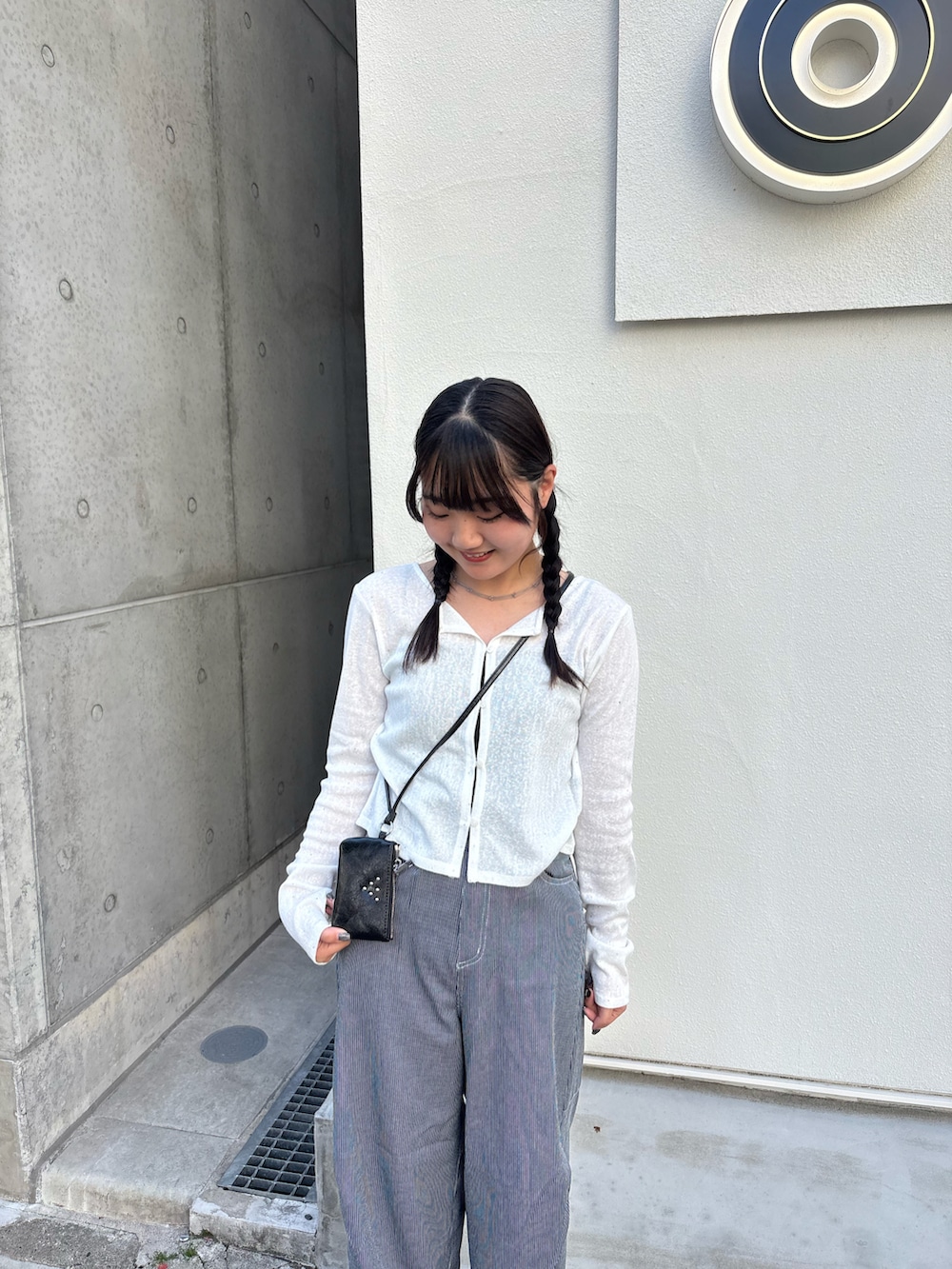 ホワイト系のカーディガン/ボレロ、ブルー系のデニムパンツ、ブラック系のパンプスを着用したレディースの春コーディネートの2枚目の写真