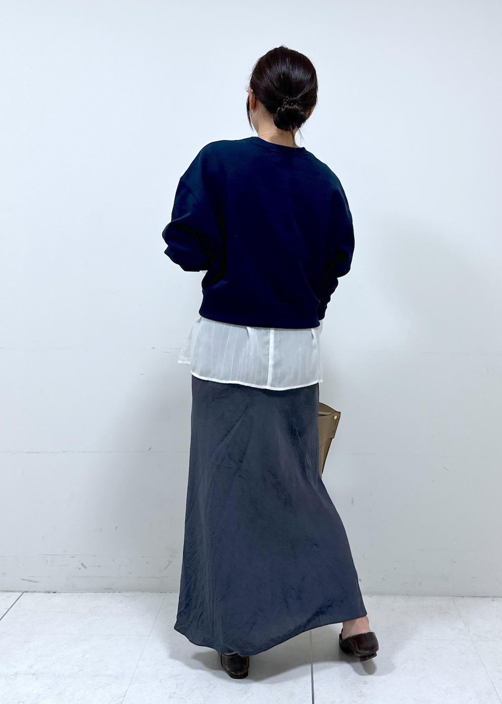 グレー系のスカート、ホワイト系のシャツ/ブラウス、ブルー系のスウェットを着用したレディースの秋コーディネートの6枚目の写真