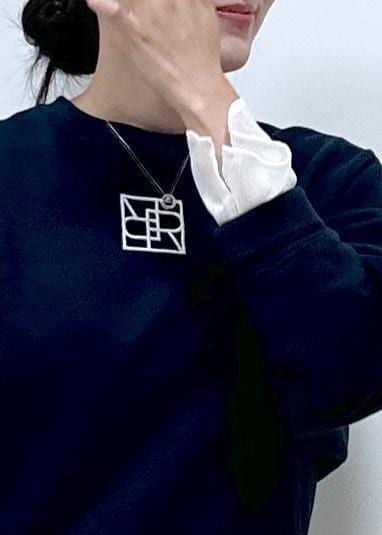 グレー系のスカート、ホワイト系のシャツ/ブラウス、ブルー系のスウェットを着用したレディースの秋コーディネートの3枚目の写真