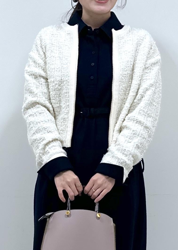 グレー系のハンドバッグ、ブルー系のワンピース、ホワイト系のカーディガン/ボレロを着用したレディースの冬コーディネートの2枚目の写真