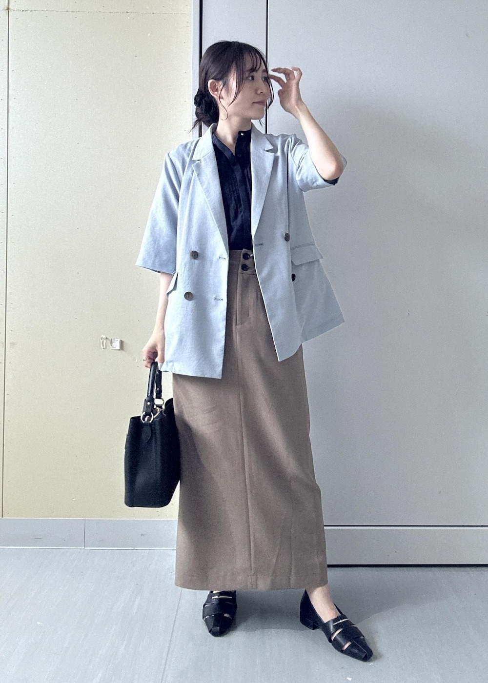 ブラック系のパンプス、ブルー系のシャツ/ブラウス、ベージュ系のスカートを着用したレディースの夏コーディネートの10枚目の写真