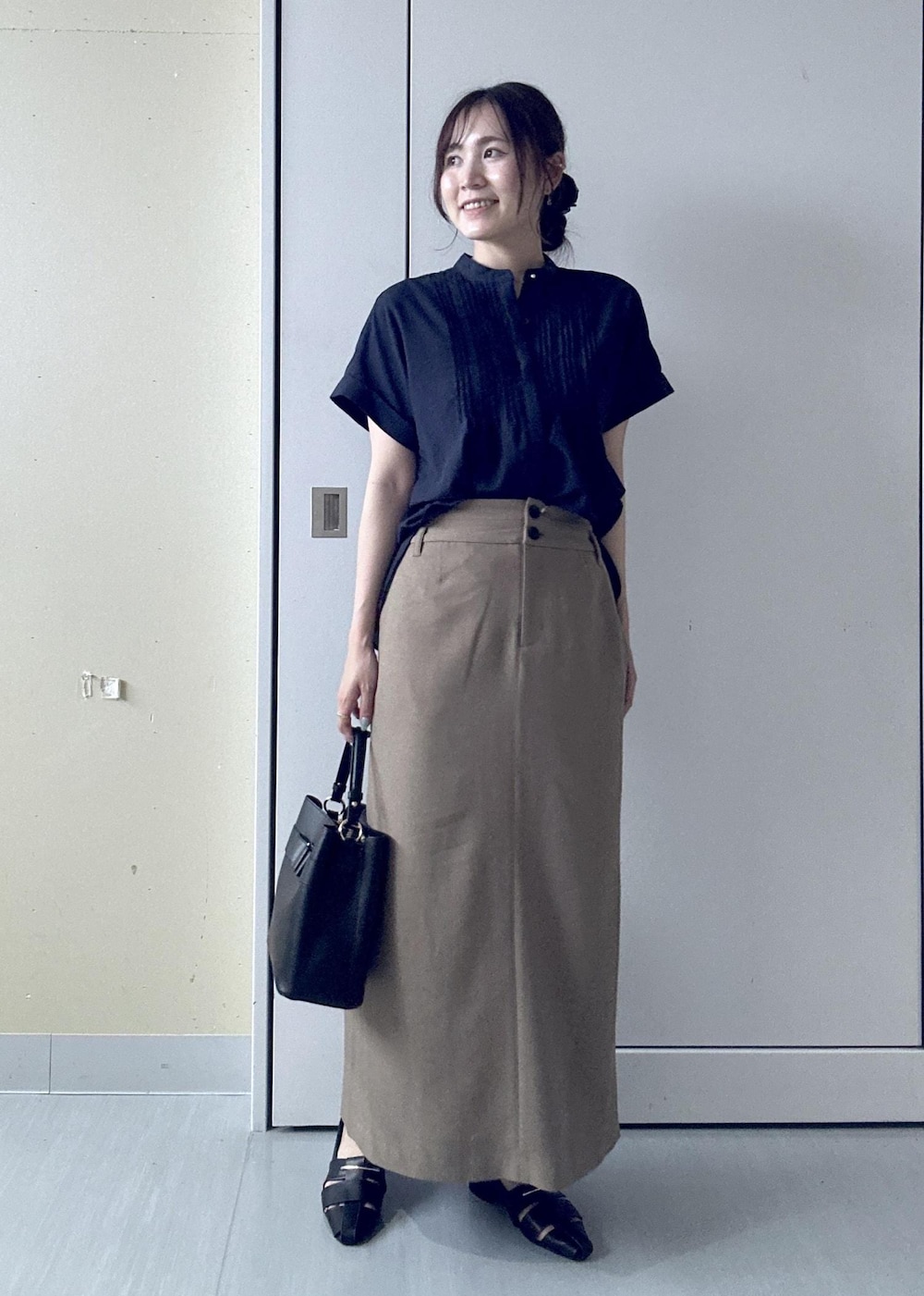 ブラック系のパンプス、ブルー系のシャツ/ブラウス、ベージュ系のスカートを着用したレディースの夏コーディネートの4枚目の写真