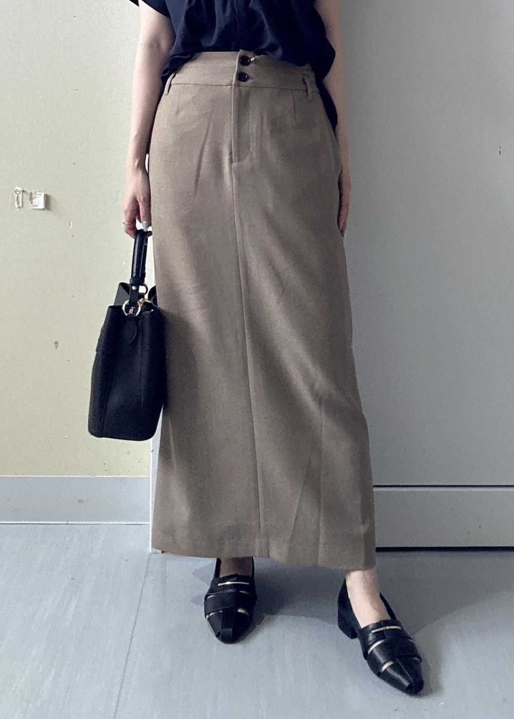 ブラック系のパンプス、ブルー系のシャツ/ブラウス、ベージュ系のスカートを着用したレディースの夏コーディネートの3枚目の写真