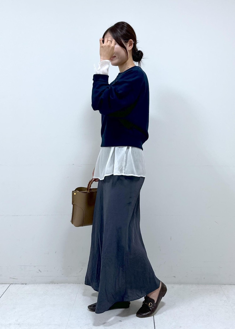 グレー系のスカート、ホワイト系のシャツ/ブラウス、ブルー系のスウェットを着用したレディースの秋コーディネートの5枚目の写真
