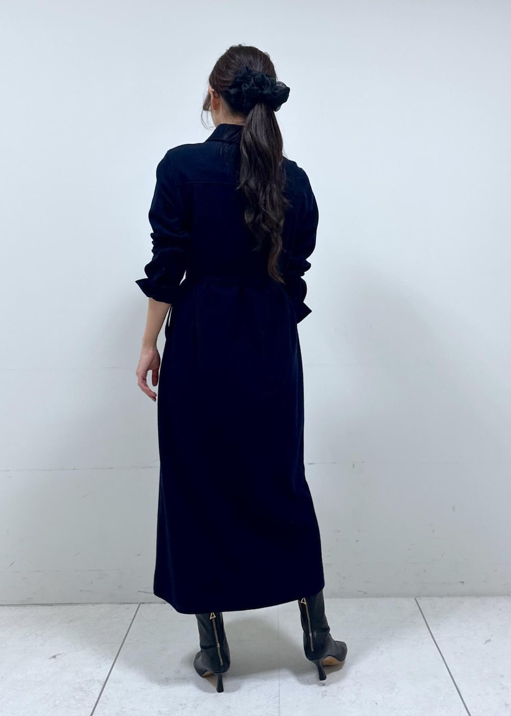 グレー系のハンドバッグ、ブルー系のワンピース、ホワイト系のカーディガン/ボレロを着用したレディースの冬コーディネートの8枚目の写真