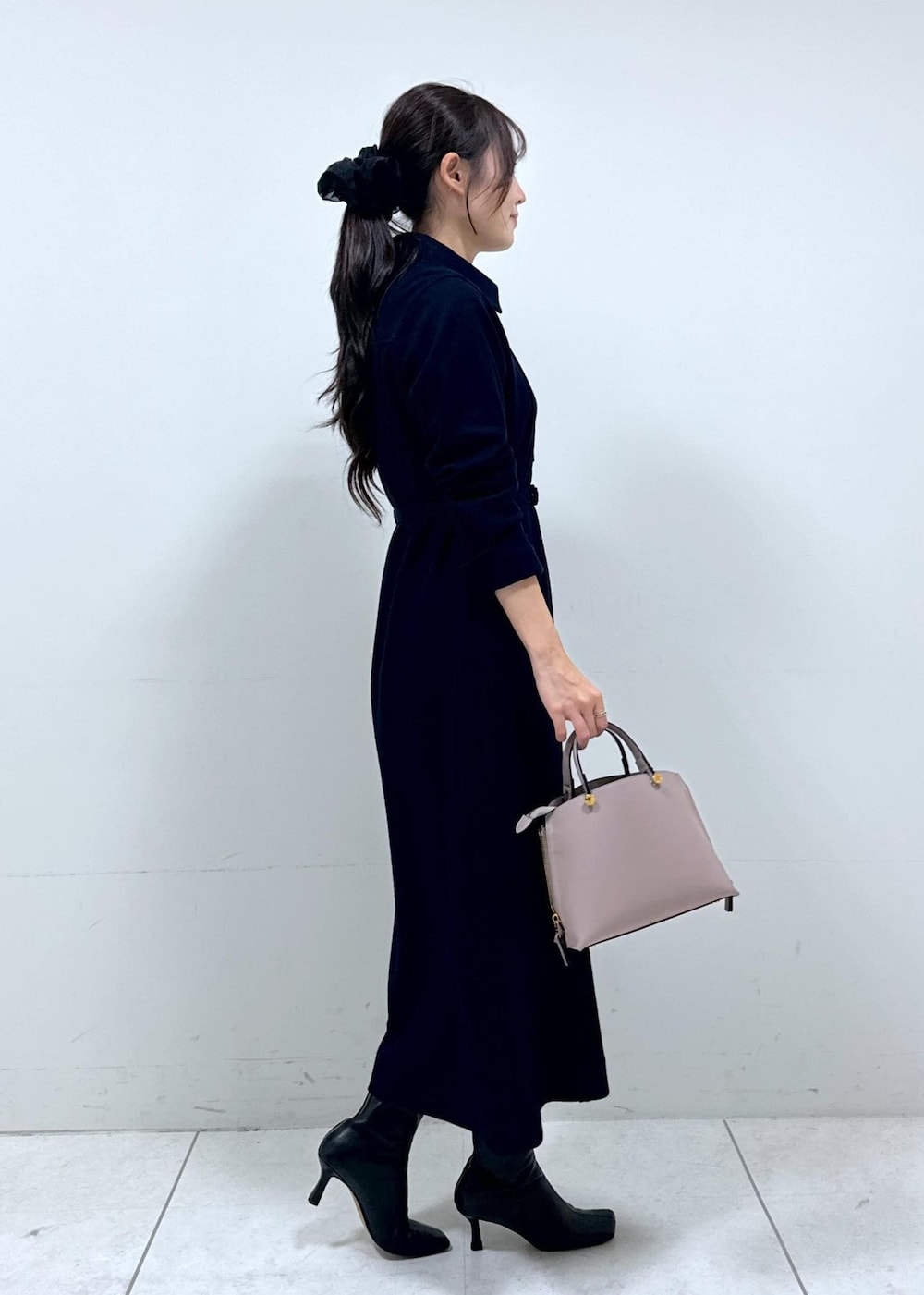 グレー系のハンドバッグ、ブルー系のワンピース、ホワイト系のカーディガン/ボレロを着用したレディースの冬コーディネートの7枚目の写真