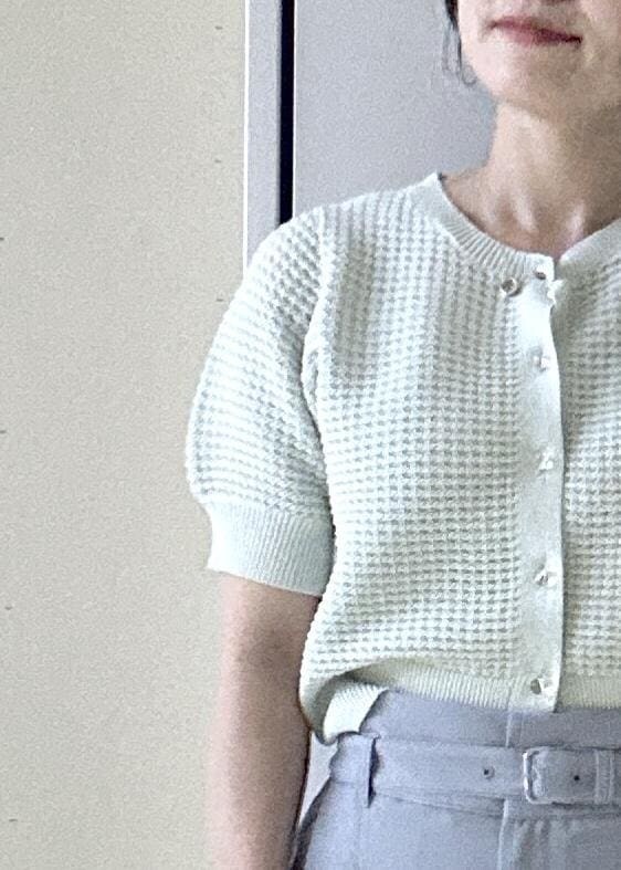 ホワイト系のトートバッグ、グリーン系のカーディガン/ボレロ、ホワイト系のパンプスを着用したレディースの春コーディネートの4枚目の写真