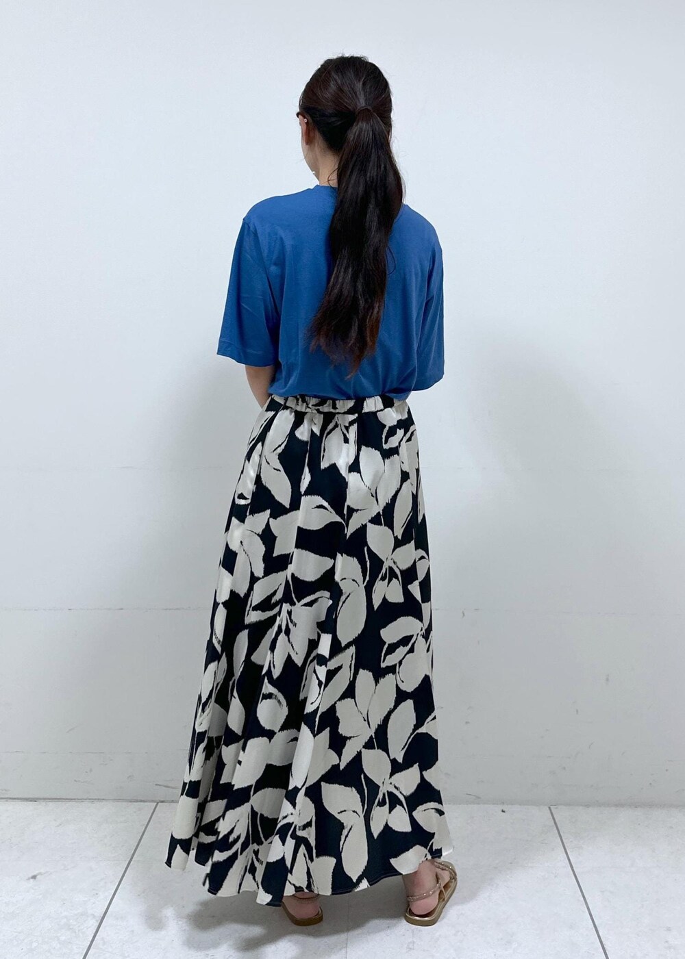 ベージュ系のハンドバッグ、ブルー系のTシャツ/カットソー、ブラック系のスカートを着用したレディースの夏コーディネートの5枚目の写真