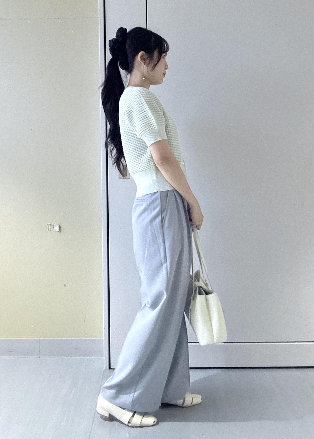 ホワイト系のトートバッグ、グリーン系のカーディガン/ボレロ、ホワイト系のパンプスを着用したレディースの春コーディネートの5枚目の写真
