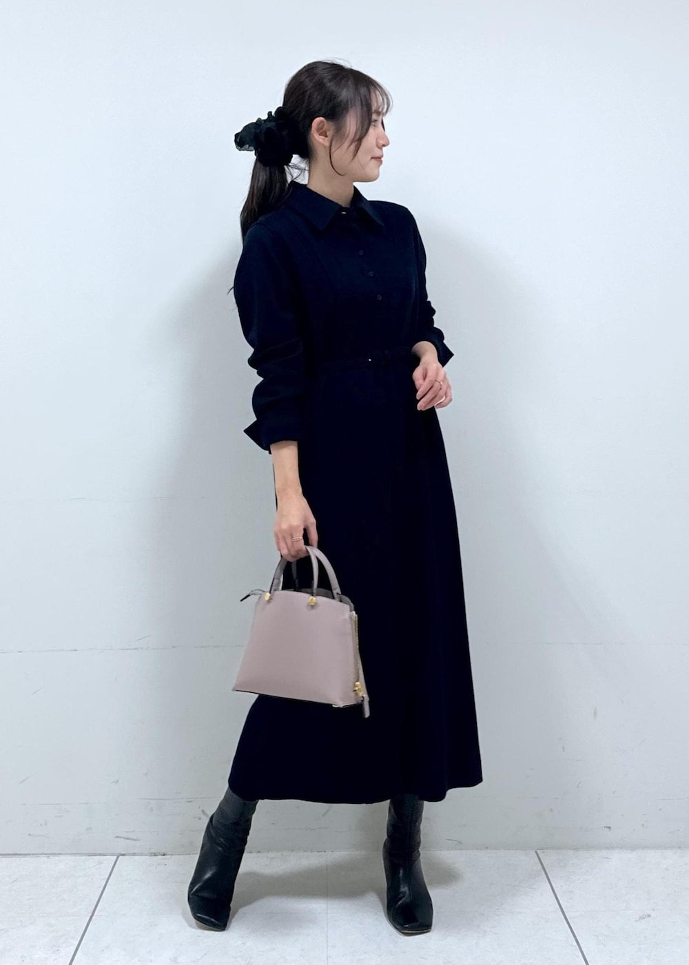 グレー系のハンドバッグ、ブルー系のワンピース、ホワイト系のカーディガン/ボレロを着用したレディースの冬コーディネートの5枚目の写真