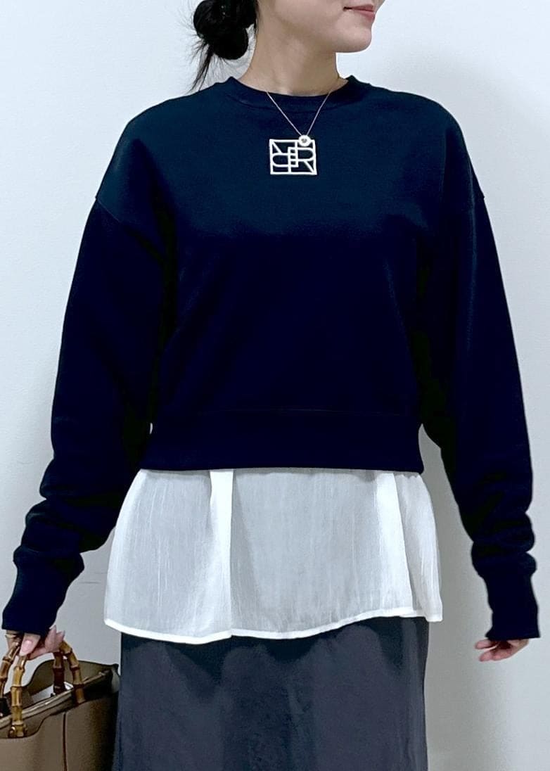 グレー系のスカート、ホワイト系のシャツ/ブラウス、ブルー系のスウェットを着用したレディースの秋コーディネートの2枚目の写真