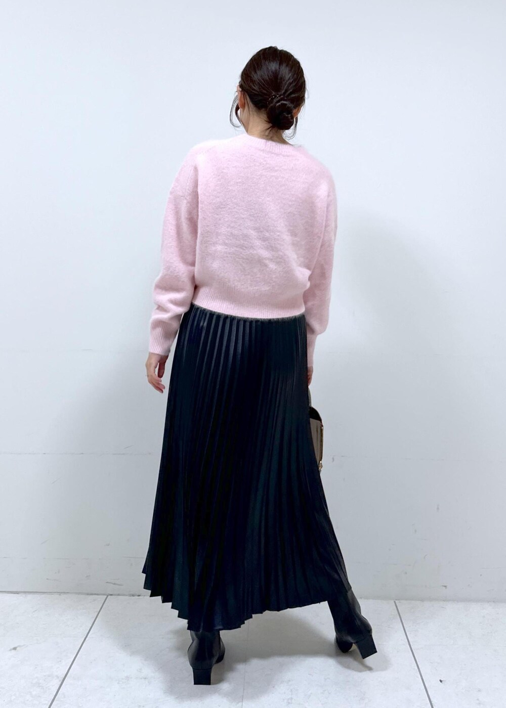 ブラック系のブーツ、ブラウン系のハンドバッグ、ホワイト系のステンカラーコートを着用したレディースの秋コーディネートの9枚目の写真