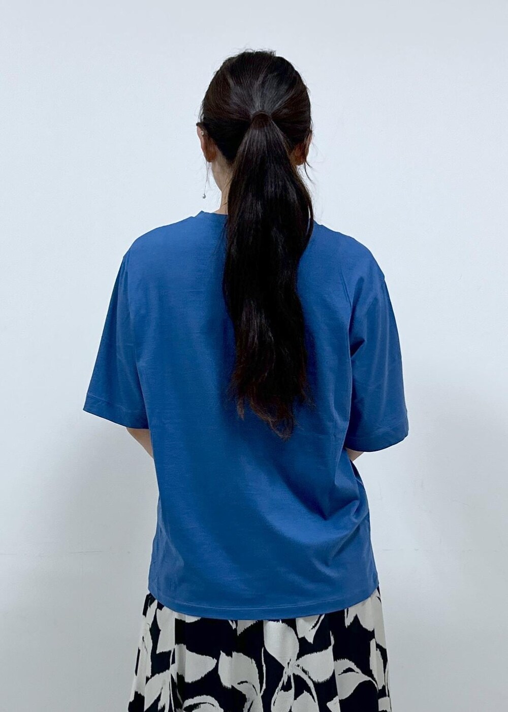 ベージュ系のハンドバッグ、ブルー系のTシャツ/カットソー、ブラック系のスカートを着用したレディースの夏コーディネートの6枚目の写真