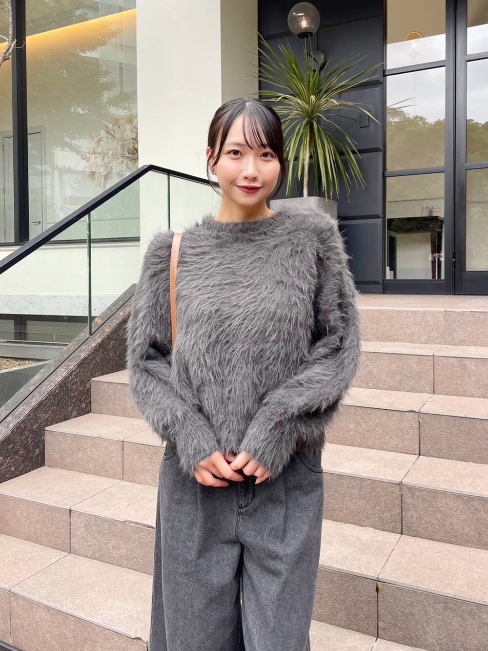 グレー系のニット/セーター、ブラック系のデニムパンツを着用したレディースの秋コーディネートの4枚目の写真