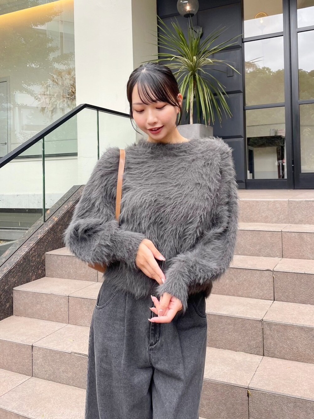 グレー系のニット/セーター、ブラック系のデニムパンツを着用したレディースの秋コーディネートの5枚目の写真