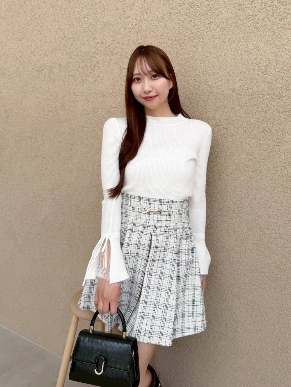 ホワイト系のニット/セーター、ホワイト系のスカート、ブラック系のブーツを着用したレディースの冬コーディネートの5枚目の写真