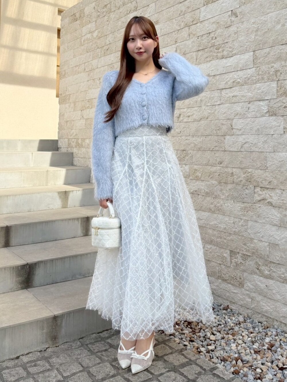 グレー系のスカート、ブルー系のカーディガン/ボレロを着用したレディースの秋コーディネートの4枚目の写真