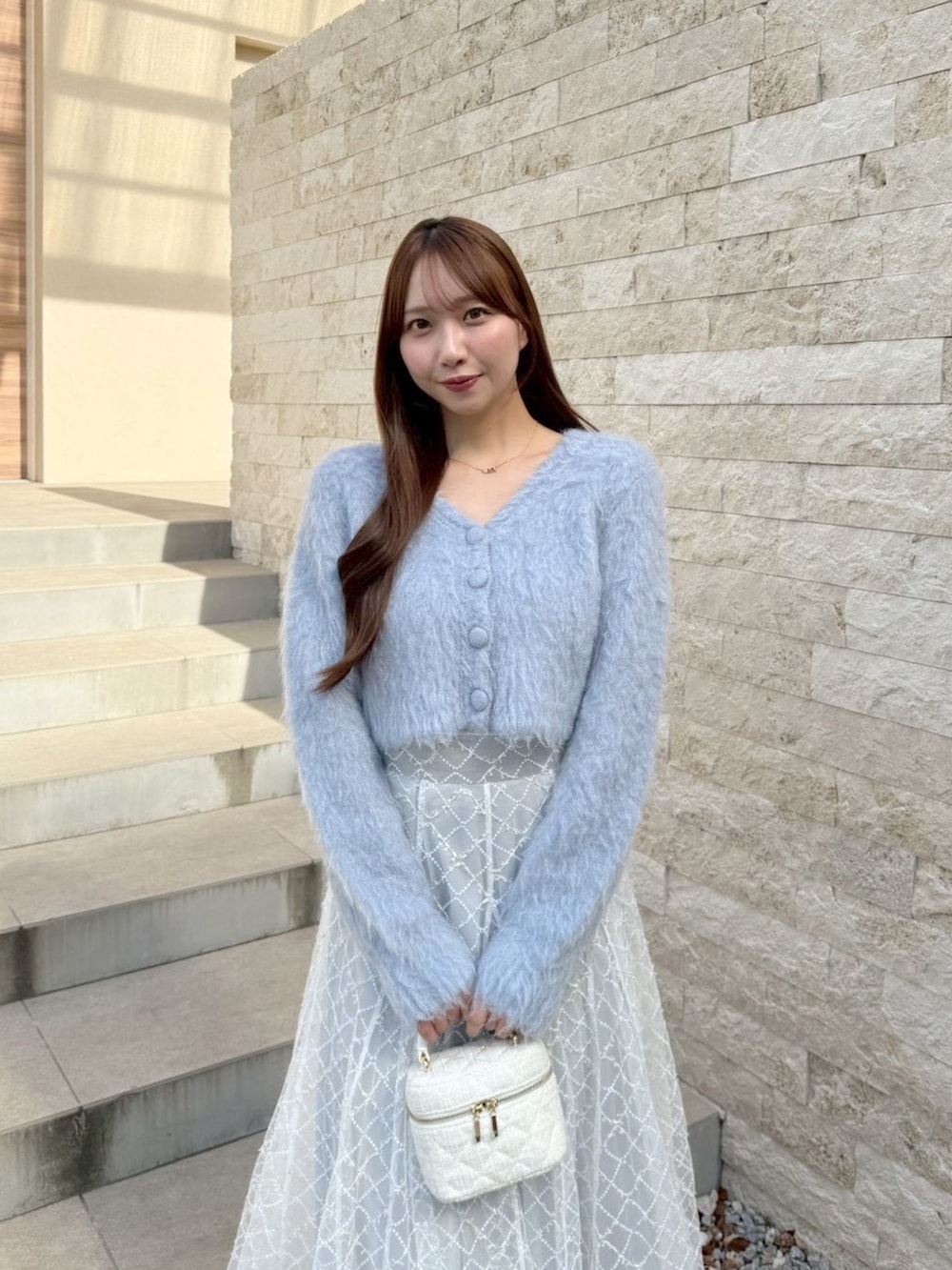 グレー系のスカート、ブルー系のカーディガン/ボレロを着用したレディースの秋コーディネートの7枚目の写真