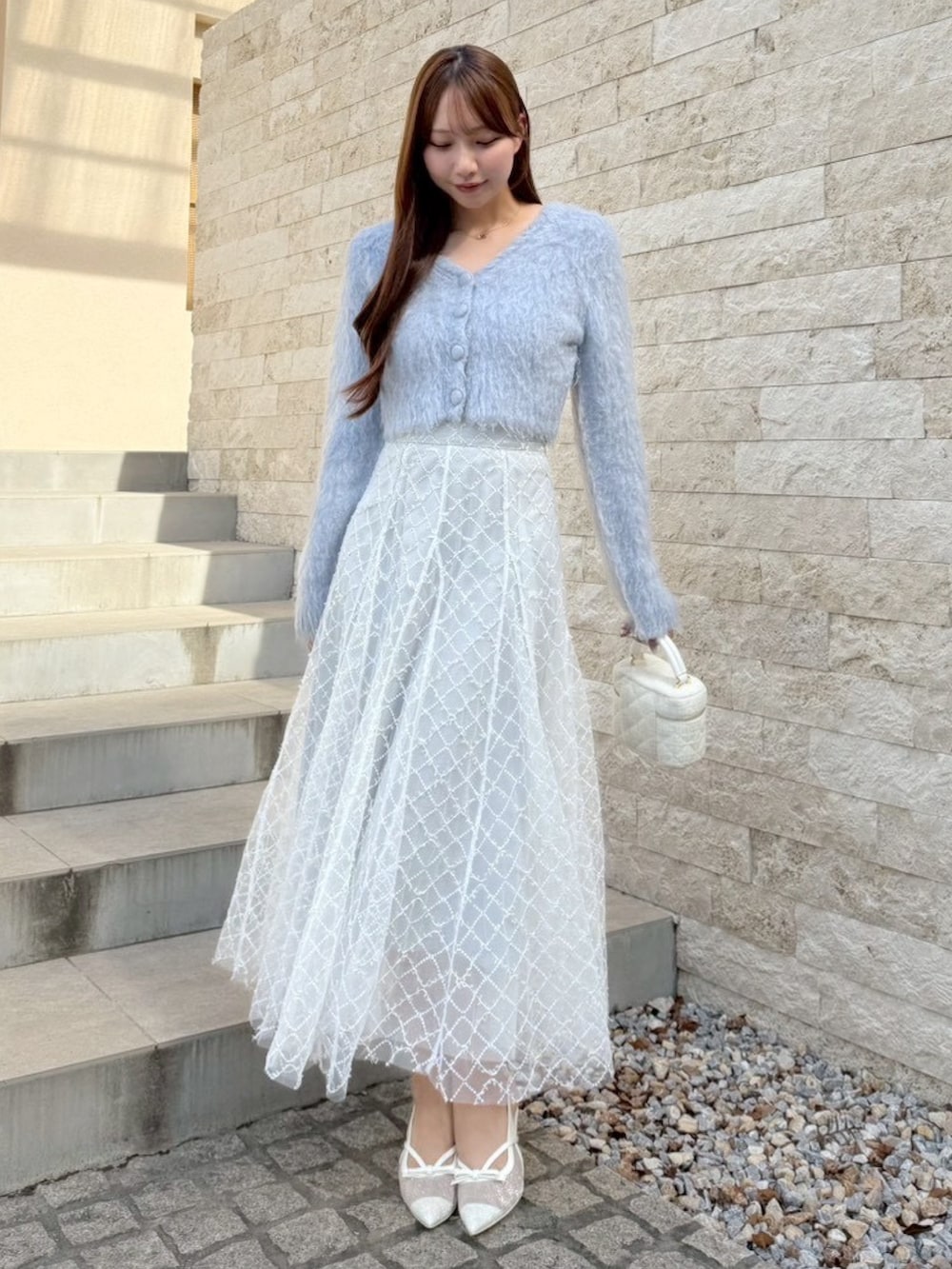 グレー系のスカート、ブルー系のカーディガン/ボレロを着用したレディースの秋コーディネートの3枚目の写真