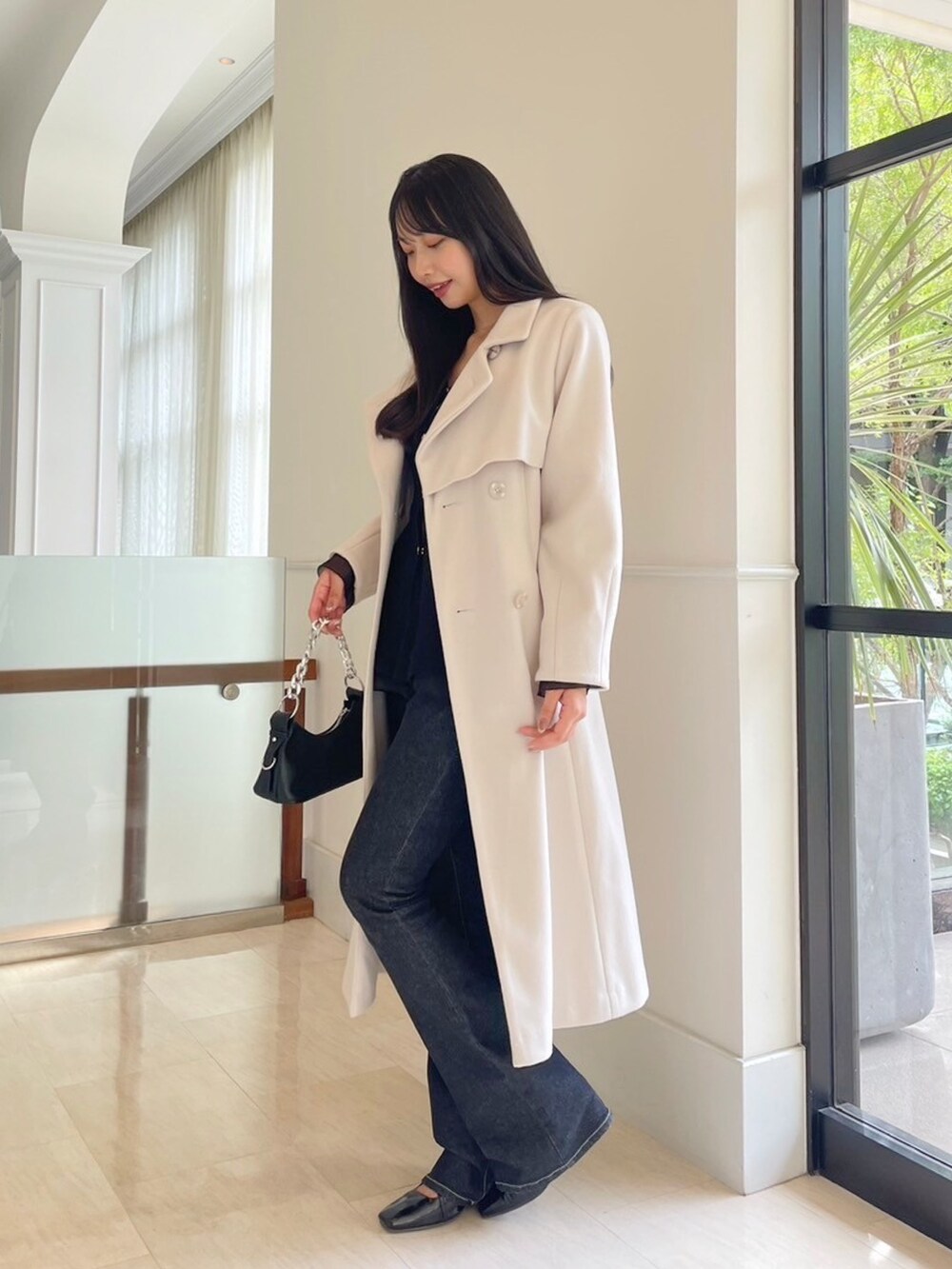 ブラック系のデニムパンツ、ブラック系のニット/セーター、ホワイト系のその他アウターを着用したレディースの秋コーディネートの4枚目の写真