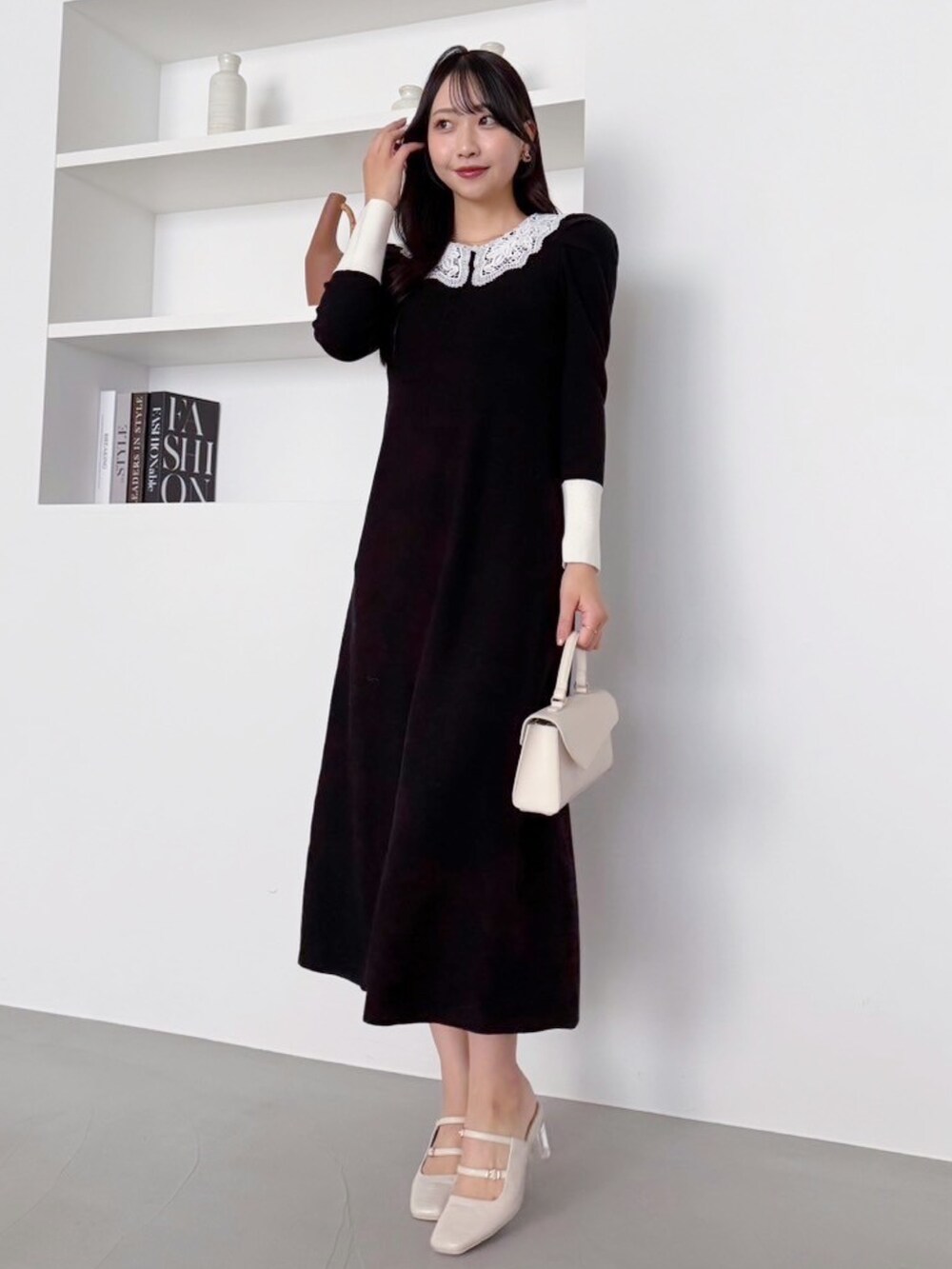 ブラック系のワンピースを着用したレディースの冬コーディネートの2枚目の写真