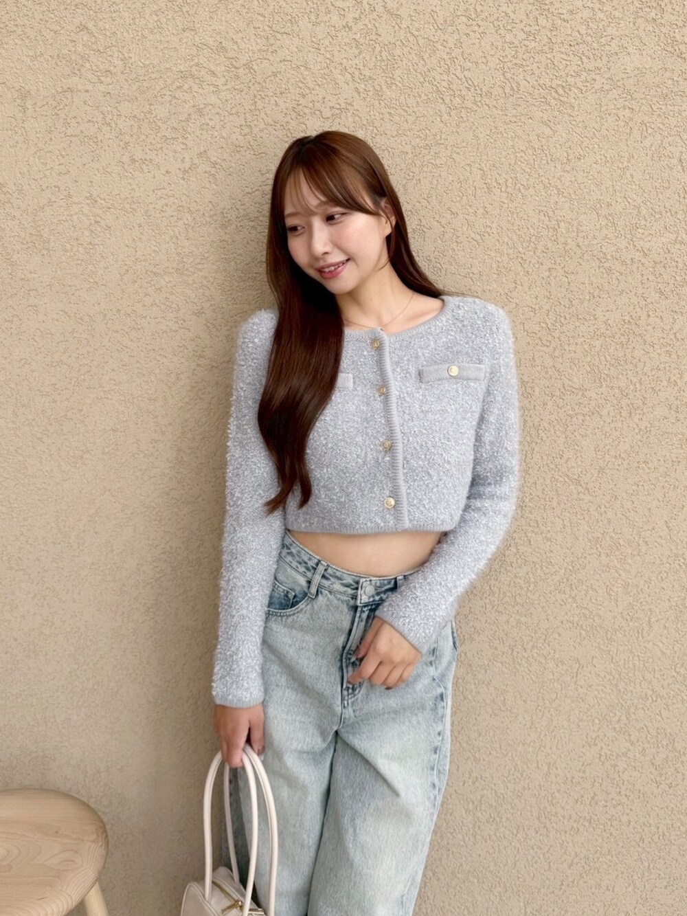 ブルー系のデニムパンツ、グレー系のノーカラージャケットを着用したレディースの秋コーディネートの4枚目の写真