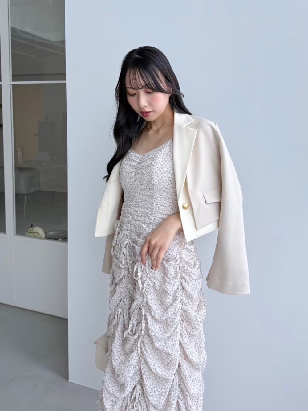 ピンク系のワンピース、ホワイト系のテーラードジャケットを着用したレディースの冬コーディネートの5枚目の写真