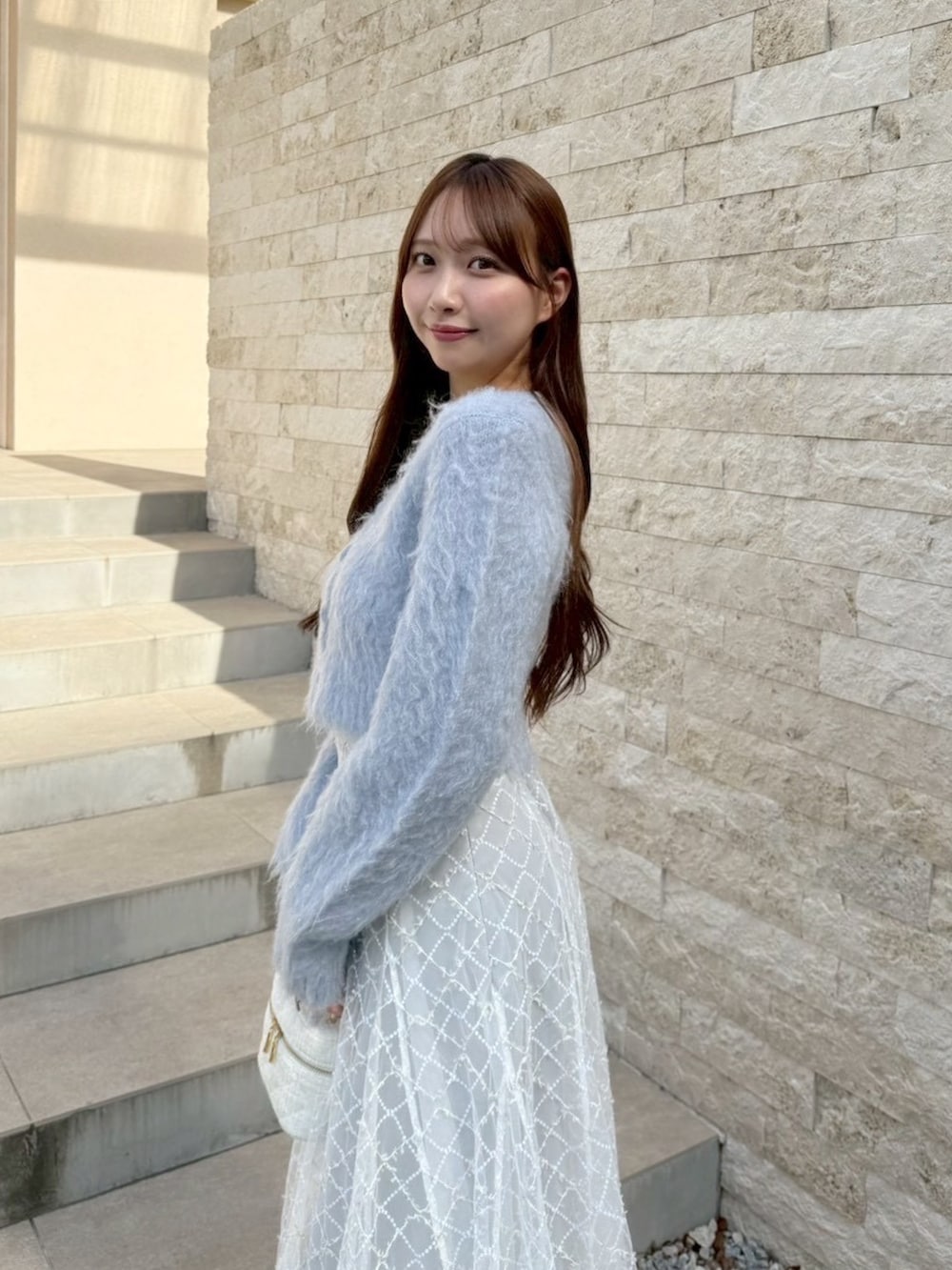 グレー系のスカート、ブルー系のカーディガン/ボレロを着用したレディースの秋コーディネートの5枚目の写真