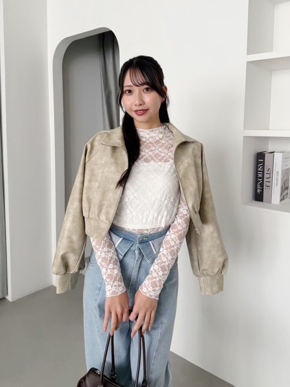 ホワイト系のTシャツ/カットソー、ブルー系のデニムパンツ、グレー系のブルゾンを着用したレディースの冬コーディネートの6枚目の写真