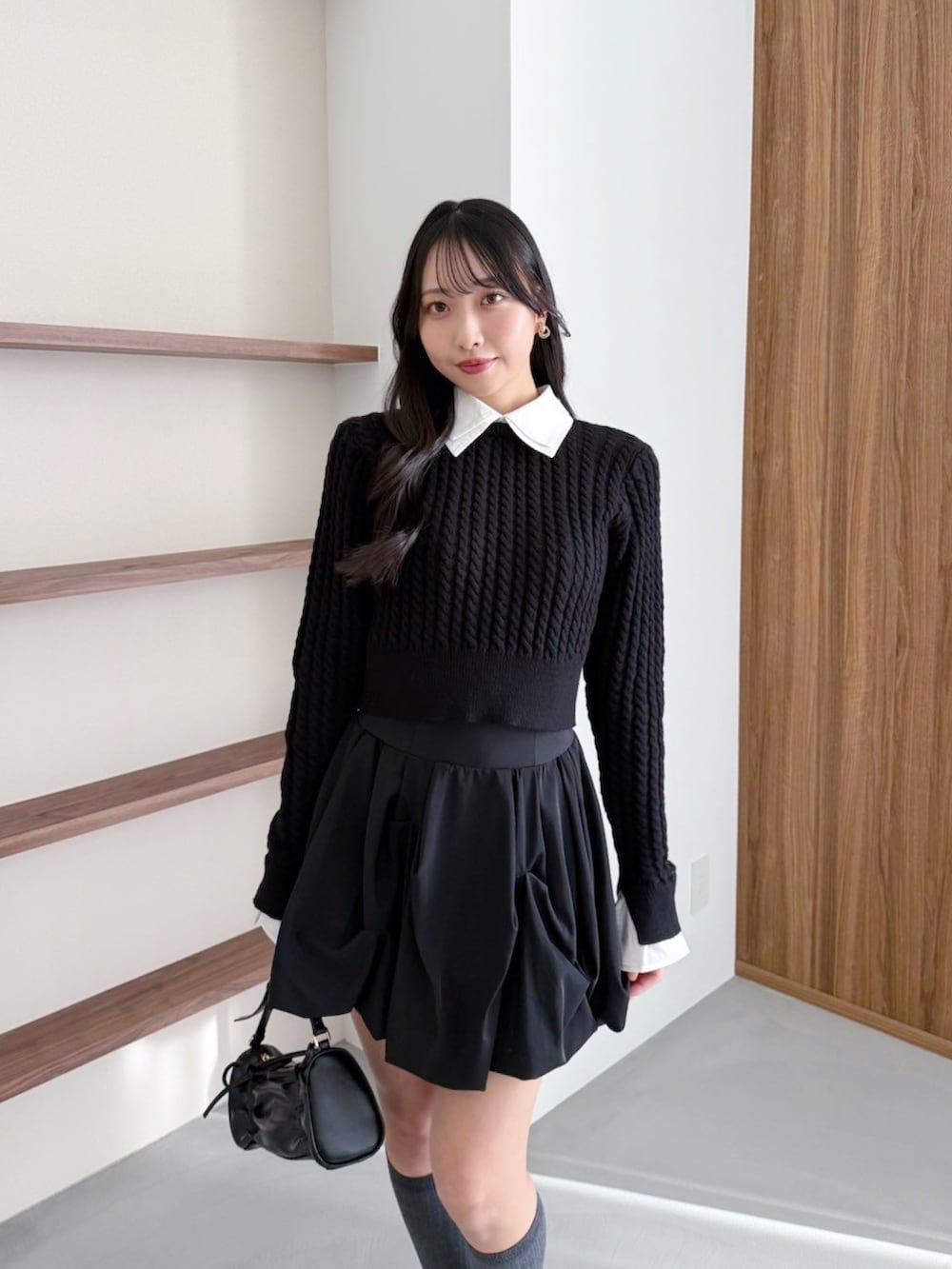 ブラック系のスカート、ブラック系のニット/セーターを着用したレディースの冬コーディネートの2枚目の写真