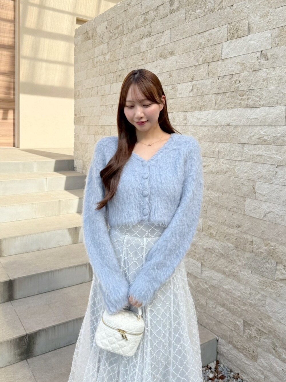 グレー系のスカート、ブルー系のカーディガン/ボレロを着用したレディースの秋コーディネートの6枚目の写真