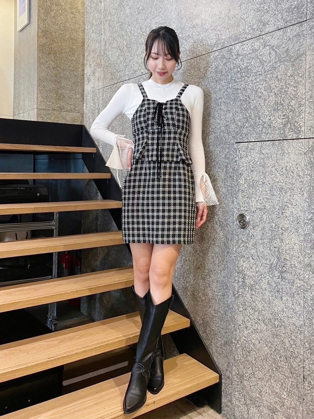 ホワイト系のニット/セーター、ブラック系のワンピースを着用したレディースの冬コーディネートの2枚目の写真