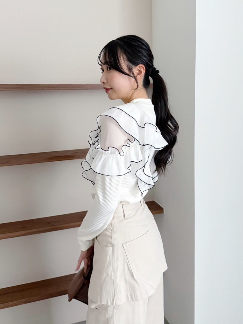 ベージュ系のデニムパンツ、ホワイト系のTシャツ/カットソーを着用したレディースの冬コーディネートの6枚目の写真