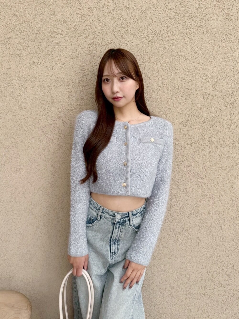 ブルー系のデニムパンツ、グレー系のノーカラージャケットを着用したレディースの秋コーディネートの3枚目の写真