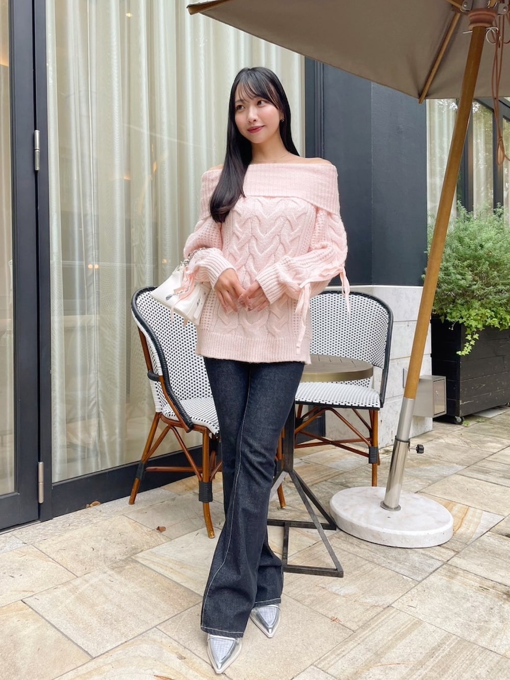 ピンク系のニット/セーター、ブルー系のデニムパンツを着用したレディースの秋コーディネートの3枚目の写真